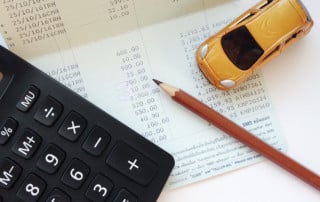 Aerial view of toy car and calculator sitting on an invoice