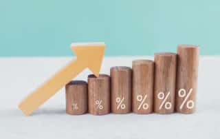 Wooden blocks with percentage sign and arrow up, financial growth, interest rate and mortgage rate increase, inflation concept