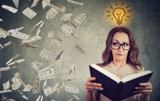 Woman student reading a book has a bright idea how to earn or save more money